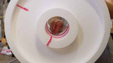 primer plano de un rollo de espuma de poliestireno con marca roja, mano en movimiento