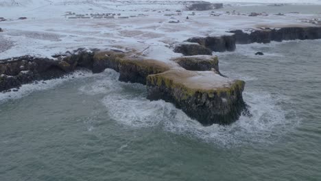 olas ásperas rompiendo en la costa rocosa de arnarstapi en invierno en islandia