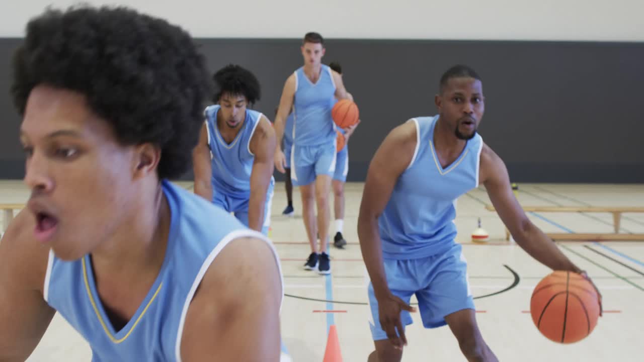 entrenamiento diverso del equipo de baloncesto masculino, dribbling con pelotas en la cancha cubierta, cámara lenta