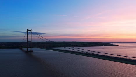 elegance in motion: humber bridge with cars at the sunset's edge