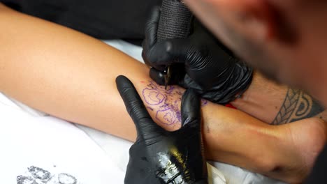 close up shot of a dog footprint tattoo while is being done over a tracing