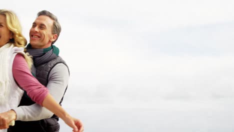 una feliz pareja madura sentada en una bicicleta con los brazos extendidos