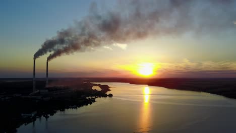 factory pipe polluting air against sunset, environmental problems, smoke from chimneys