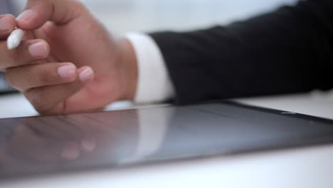 close up businessman hand working electronic signature on tablet by stylus. write business agreement of contract. man signing contract on tablet. business and technology concept.