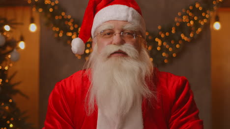 foto de la cabeza mirando a la cámara feliz viejo santa claus barbudo con disfraz y agitando la mano video llamando en zoom grabación de video felicitación de navidad cara vista de la cámara de alta calidad 4k