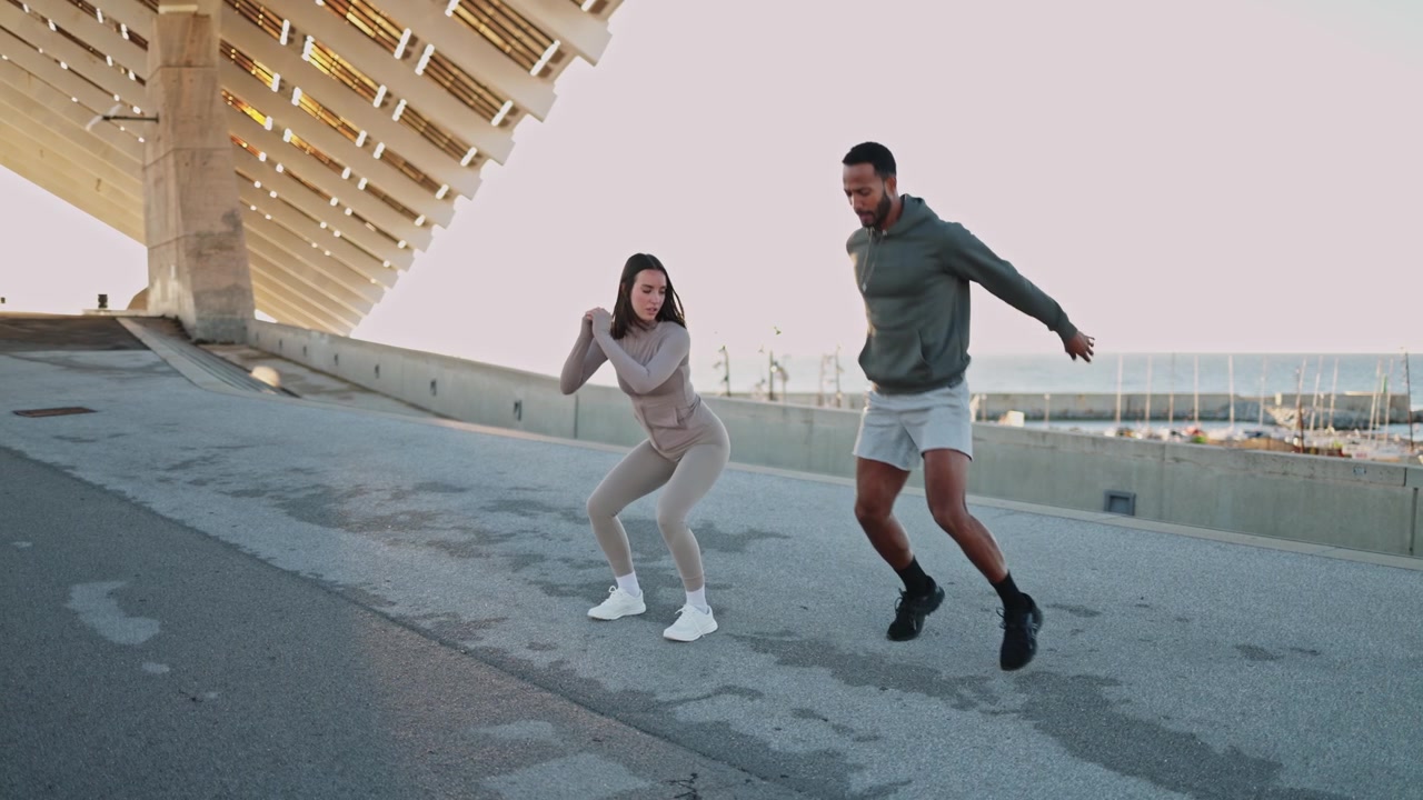 Personal Trainer Coaching Woman During Outdoor Squat Jump Exercise