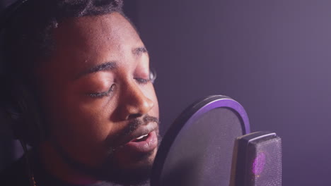 man singing into a microphone in a recording studio