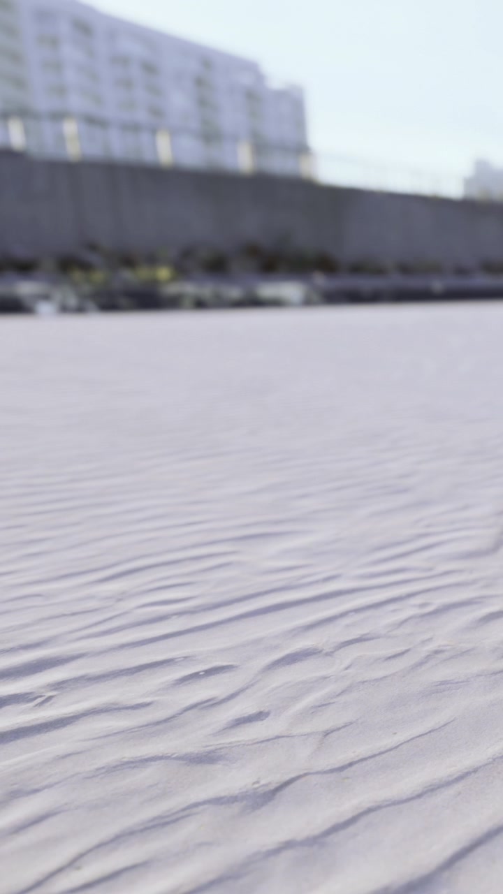 White sand with soft ripples under bright sunlight at beach location