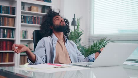 young arabian man calms himself working in office does meditation pose