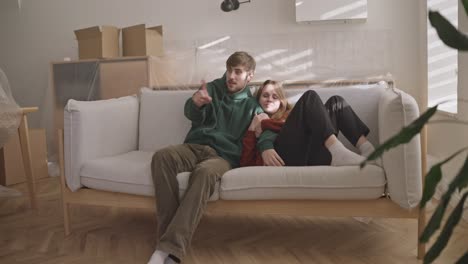 couple relaxing on couch during house move