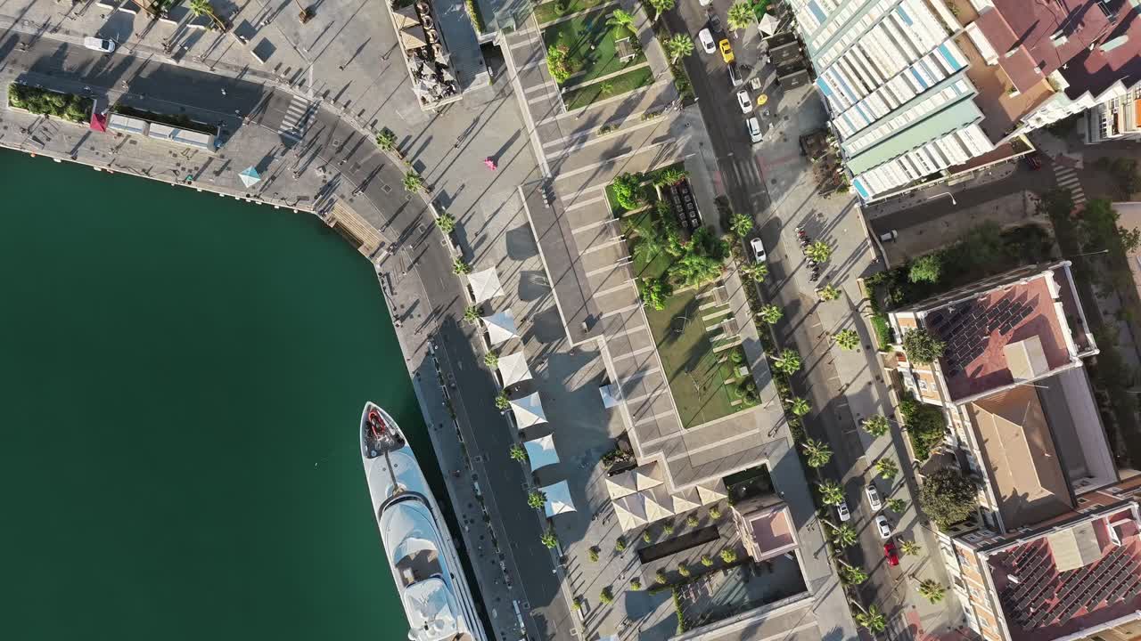 Top down view of Malaga at the water, showcasing traffic, skyscrapers, and boats in motion