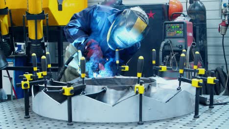trabajador en la soldadura de la fabricación de máscaras de protección de la unidad industrial. proceso de soldadura