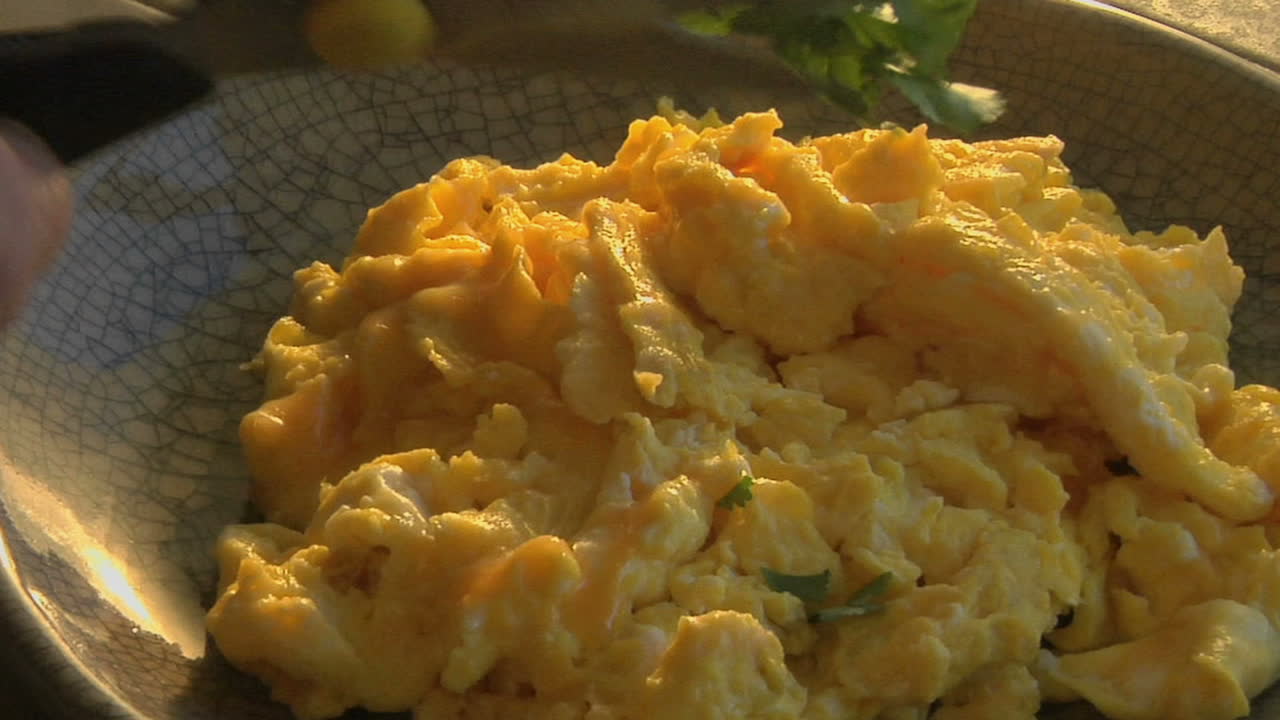 un tirón lento en un tazón de huevos revueltos mientras se corta el perejil 1