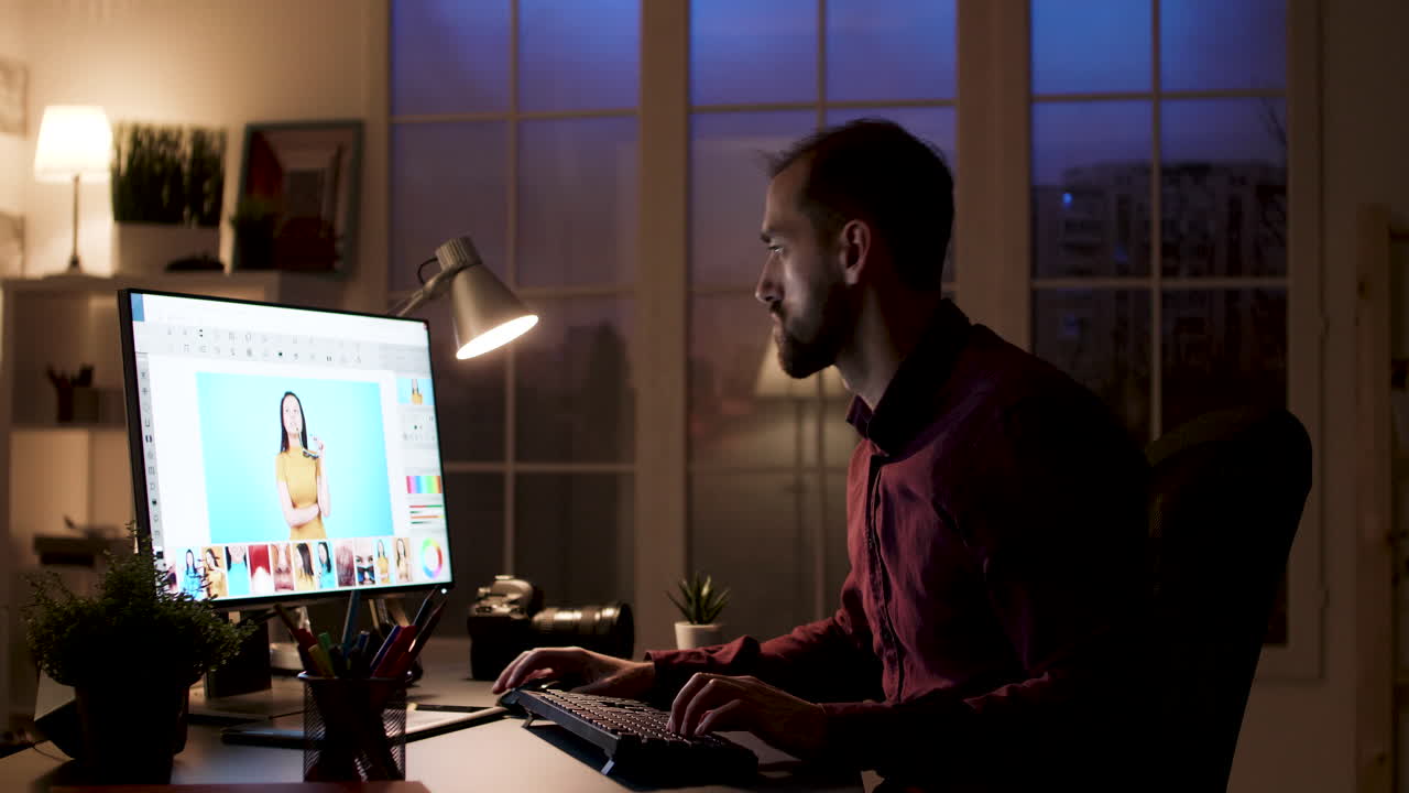 Man editing photos on computer at night