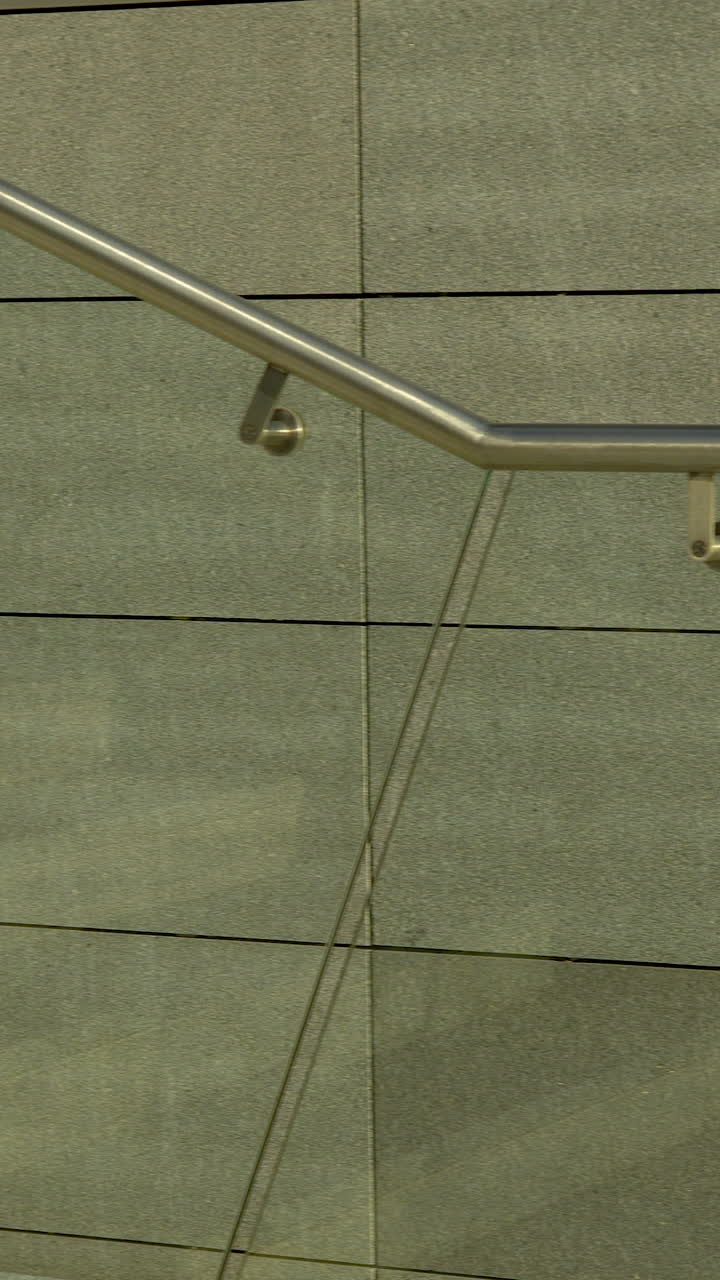 Cận cảnh cầu thang đá granite tối giản và lan can kim loại trong môi trường đô thị hiện đại. Hoàn hảo cho nội dung thiết kế kiến trúc và phát triển đô thị.