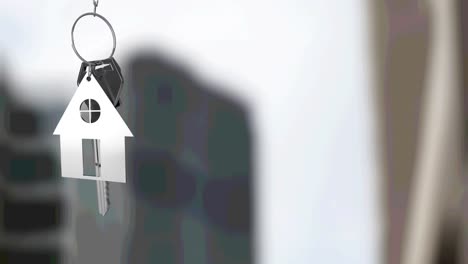 animation of silver house key fob and key, hanging in front of blurred city high rise building