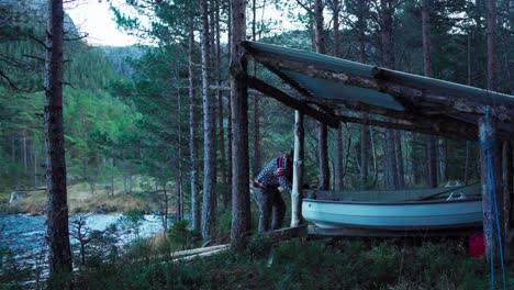 Mann-Lässt-Das-Kleine-Boot-In-Hildremsvatnet,-Norwegen,-In-Den-Fluss-Laufen