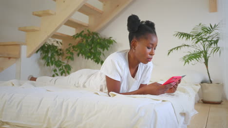 woman relaxing on a bed, using her phone