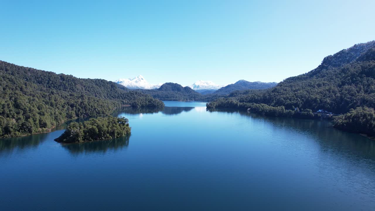 lago azul profundo rodeado de bosques y montañas, vista aérea