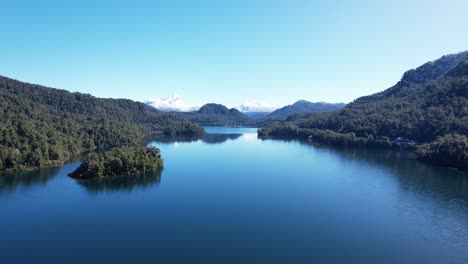 lago azul profundo rodeado de bosques y montañas, vista aérea