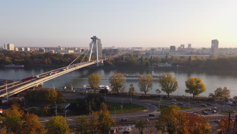 Bratislava,-Eslovaquia-En-El-Soleado-Día-De-Otoño,-Tráfico-Por-Carretera-Y-Puente-Snp,-Río-Danubio-Y-Horizonte-Brumoso