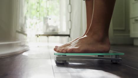 mujer comprobando su peso en la báscula en casa 4k