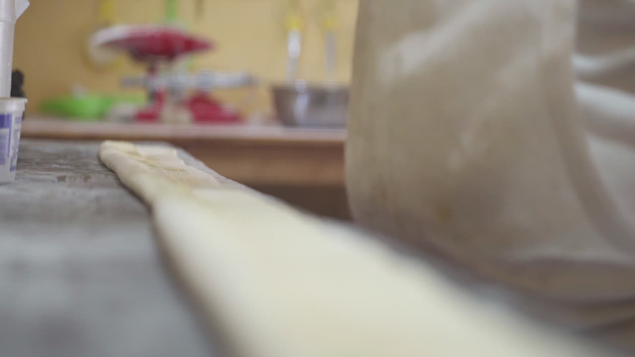 A pastry chef uses a brush to moisten dough with water or egg wash, ensuring an even browning during baking