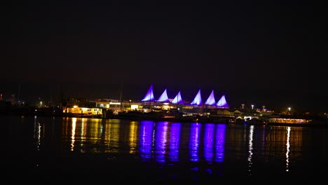 puerto iluminado con luces púrpuras vibrantes por la noche