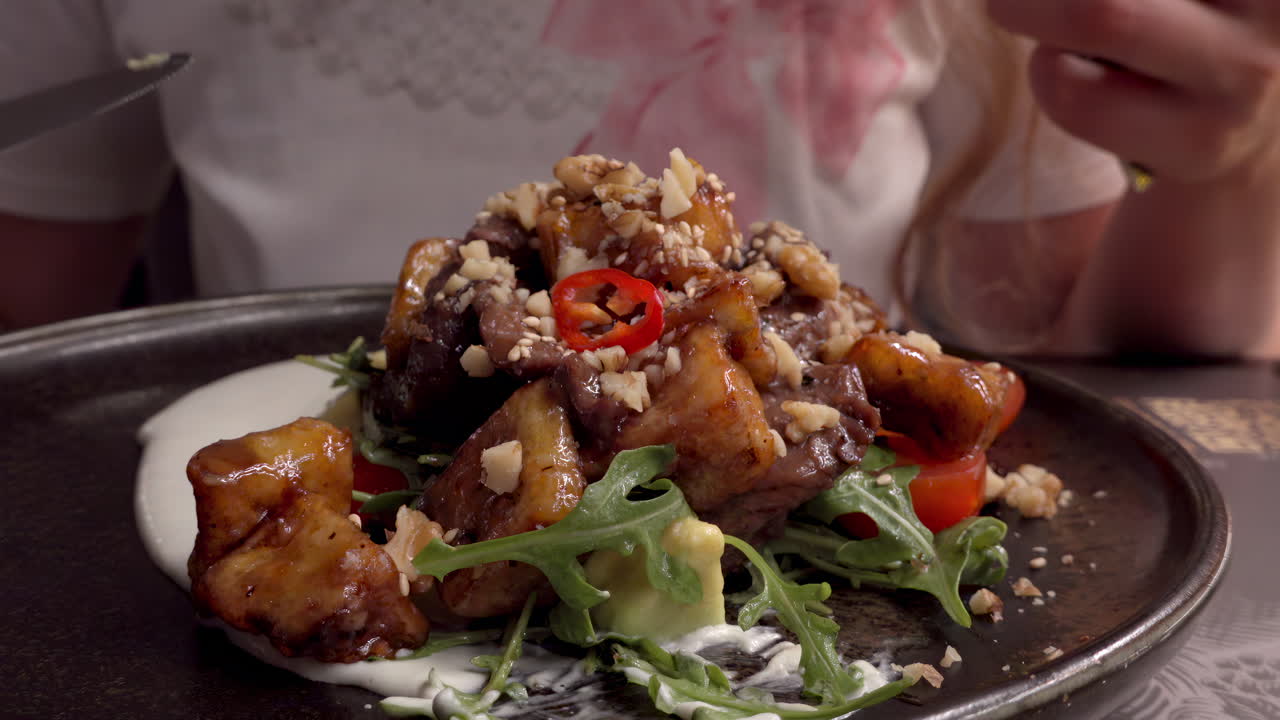 Woman eating a hot salad with veal at a restaurant