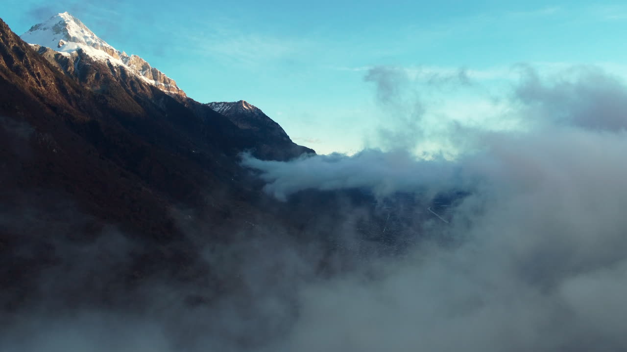 스위스의 고산 도시인 마티니를 드러내는 낮은 구름 사이를 날고 있다