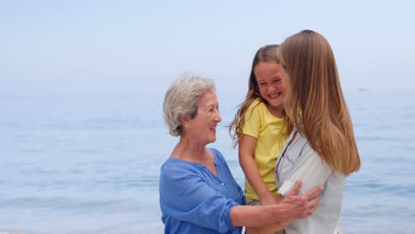 mehrgenerationsfamilie umarmt sich am strand