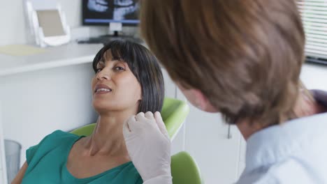 enfermera dental caucásica hablando con una paciente en una clínica dental moderna