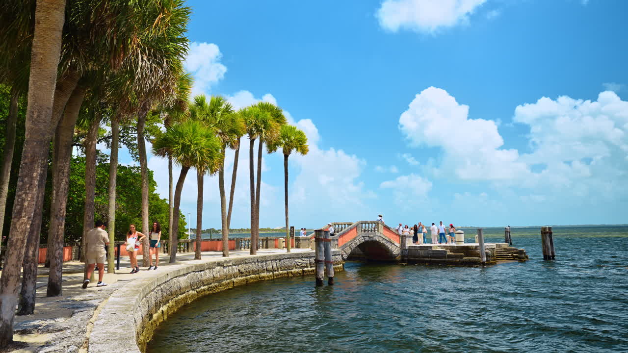 Miami, USA, 16 aprile 2026: Palme e ponte in pietra a Vizcaya. Passeggiata sul lungomare fiancheggiata da palme con storico ponte in pietra al Museo Vizcaya a Miami, Florida.