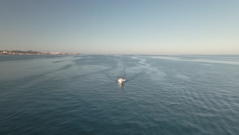 aerial view of yacht cruising peaceful spanish seascape coastline aerial orbit passing right