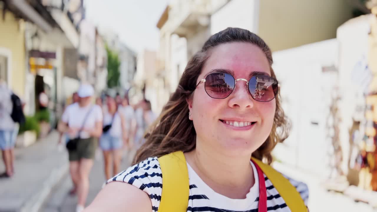 ギリシャ、アテネの混雑した通りを歩く若い女性観光客