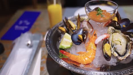 seafood platter on ice with shrimp, oysters, muscles and octopus, close slow pan
