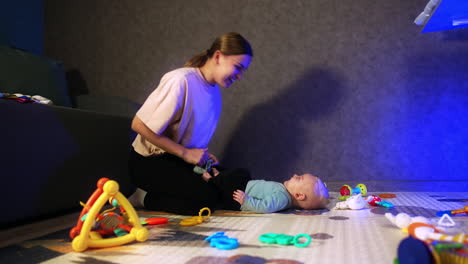 mom playing hide-and-seek with her infant baby. little child lies on the floor in front of mom smiling adorably.