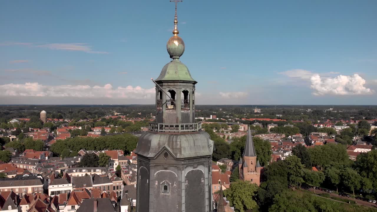 ascender antena de la catedral walburgiskerk con veleta dorada en la ciudad hanseática medieval zutphen en los países bajos mostrando drogenapstoren y watertower detrás en paisaje holandés plano