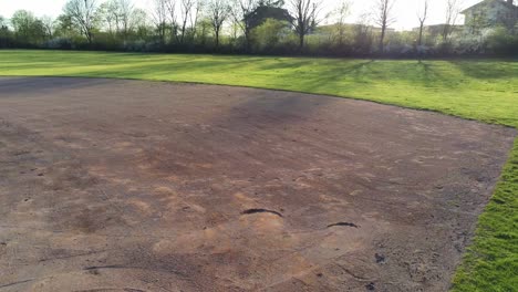 Drone-flying-over-first-base-towards-second-based-over-green-baseball-field-in-Germany