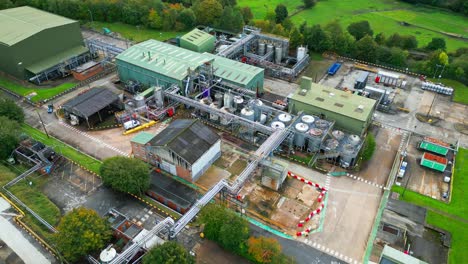 las imágenes aéreas se acercan a una gran planta química industrial en el reino unido, revelando tuberías, estructuras metálicas, torres de refrigeración y almacenamiento químico