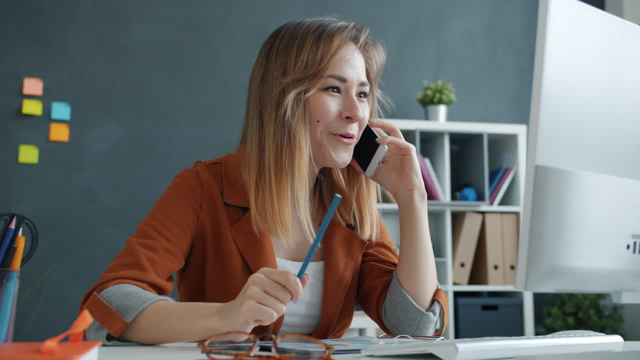 Kvinne som har en overrasket telefonsamtale på kontoret