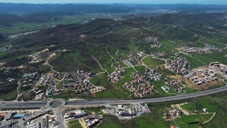 residential developments on outskirts of capital, adjacent to highway, nestled in the hills in albania