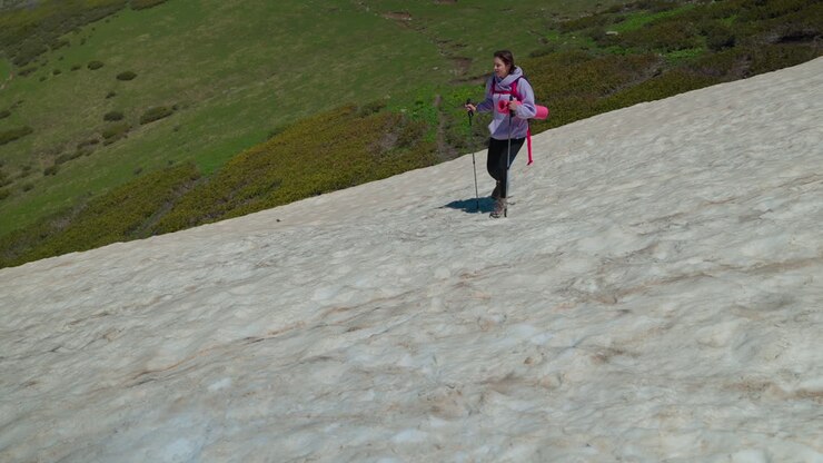 Woman Hiking on a Snowy Mountain Slope