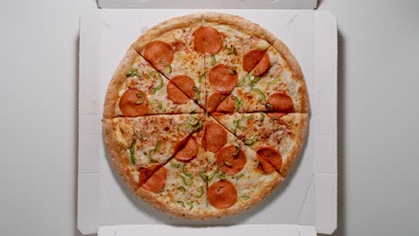 la mano humana toma una rebanada de pizza de la caja de papel