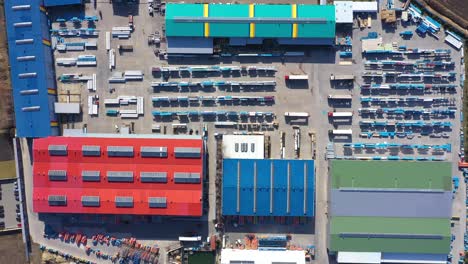 aerial view of a semi trucks with cargo trailers standing on warehouses ramps for loading unloading goods on the big logistics park with loading hub