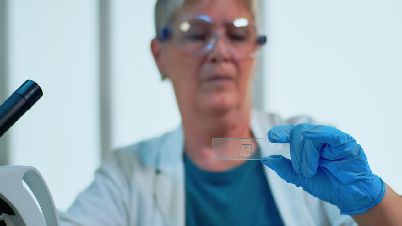 Elderly scientist checking virus evolution looking at samples