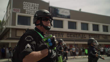 police officer armed with a shotgun during a protest in front of the city hall