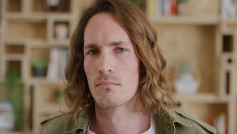 portrait-of-young-man-looking-pensive-contemplative-at-camera-handsome-caucasian-male-with-long-hair-indoors-background