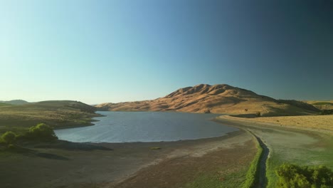 aerial view of a calm lake surrounded by dry hills and mountains