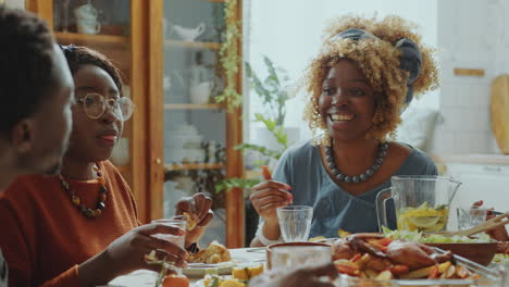 african american woman having conversation with family on holiday dinner